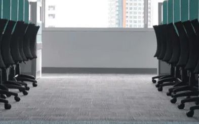 a row of office chairs are lined up in a conference room .