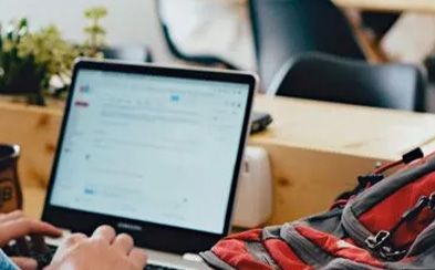 a person is sitting at a table using a laptop computer .