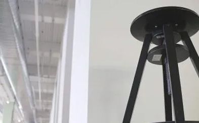 a black stool is sitting in a room next to a white wall .