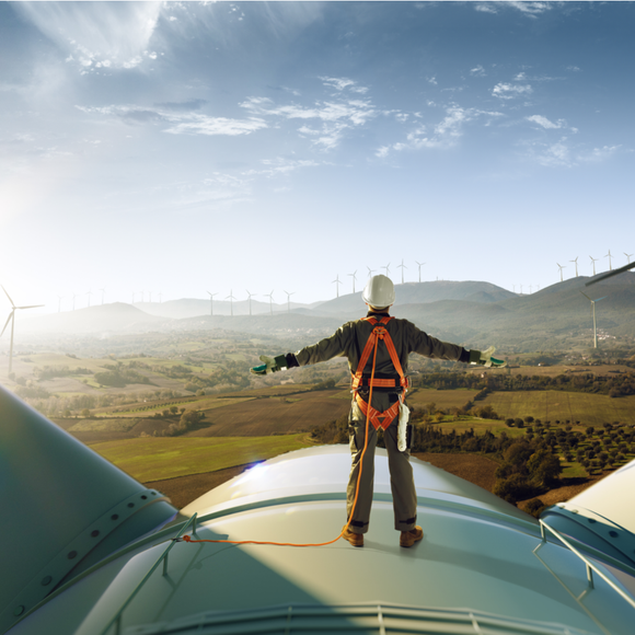 man standing on a wind propeller green energy