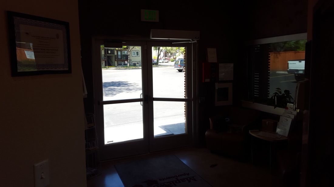 A dark room with a glass door and a picture on the wall