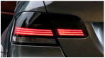 A close up of a car 's tail light with red lights.