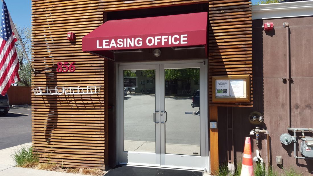 A building with a red awning that says leasing office