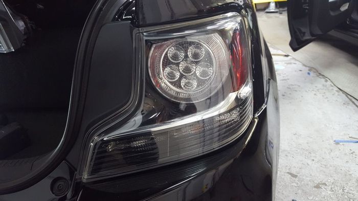 A close up of a black car 's tail light.