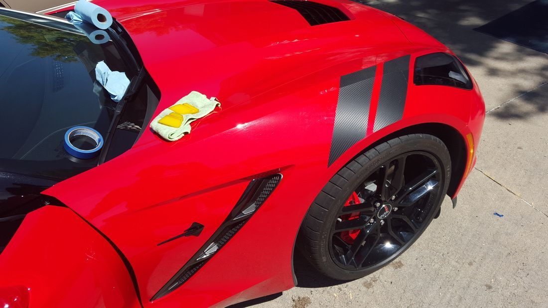 A red sports car with a parking ticket on it