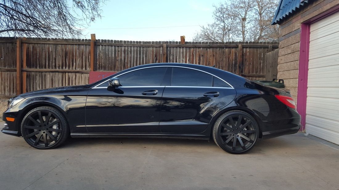 A black car is parked in front of a garage.