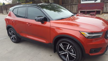 A red volvo xc40 is parked on the side of the road.