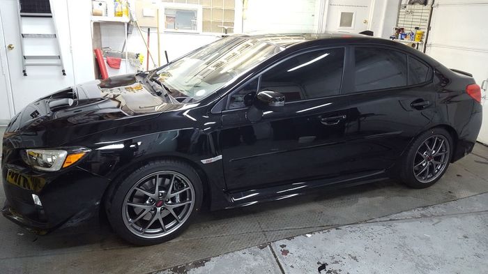 A black car is parked in a garage.