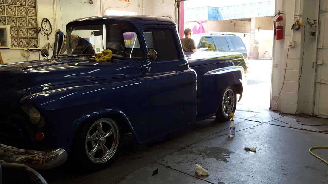 A blue truck is parked in a garage.