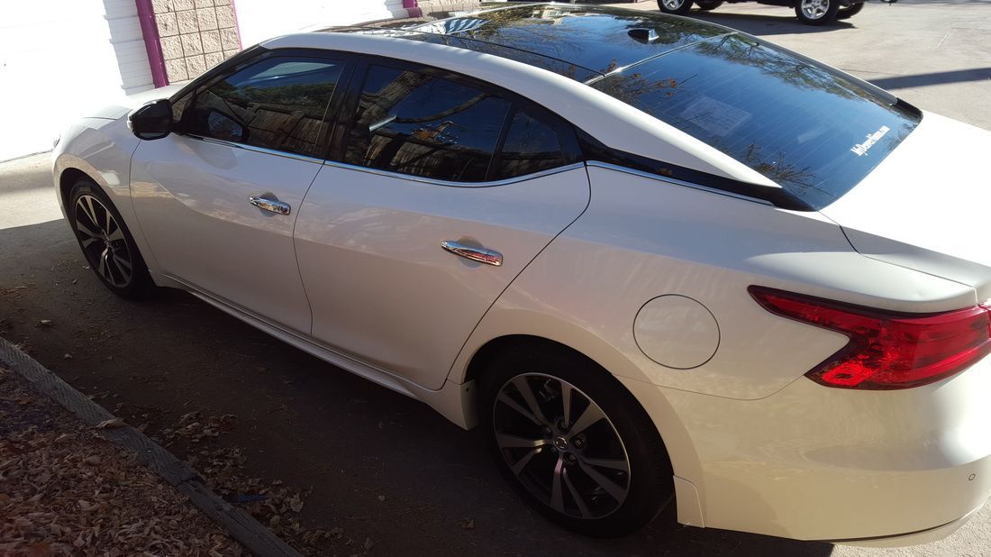 A white car is parked in a parking lot.