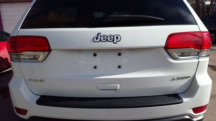 A white jeep is parked in front of a house.