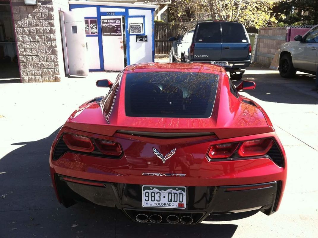 A red corvette is parked in a parking lot