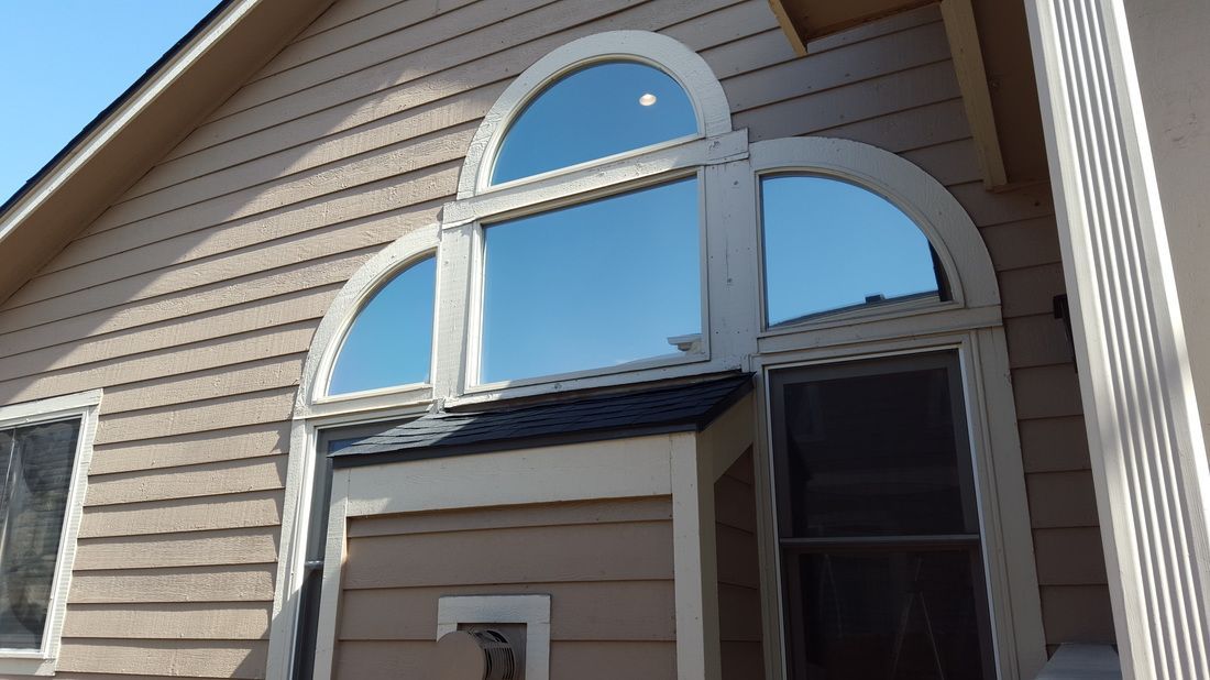 A house with arched windows and a blue sky in the background.