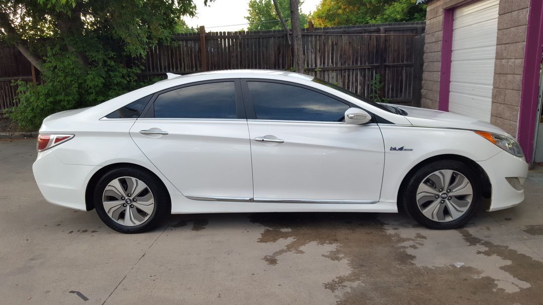A white car is parked in front of a garage.