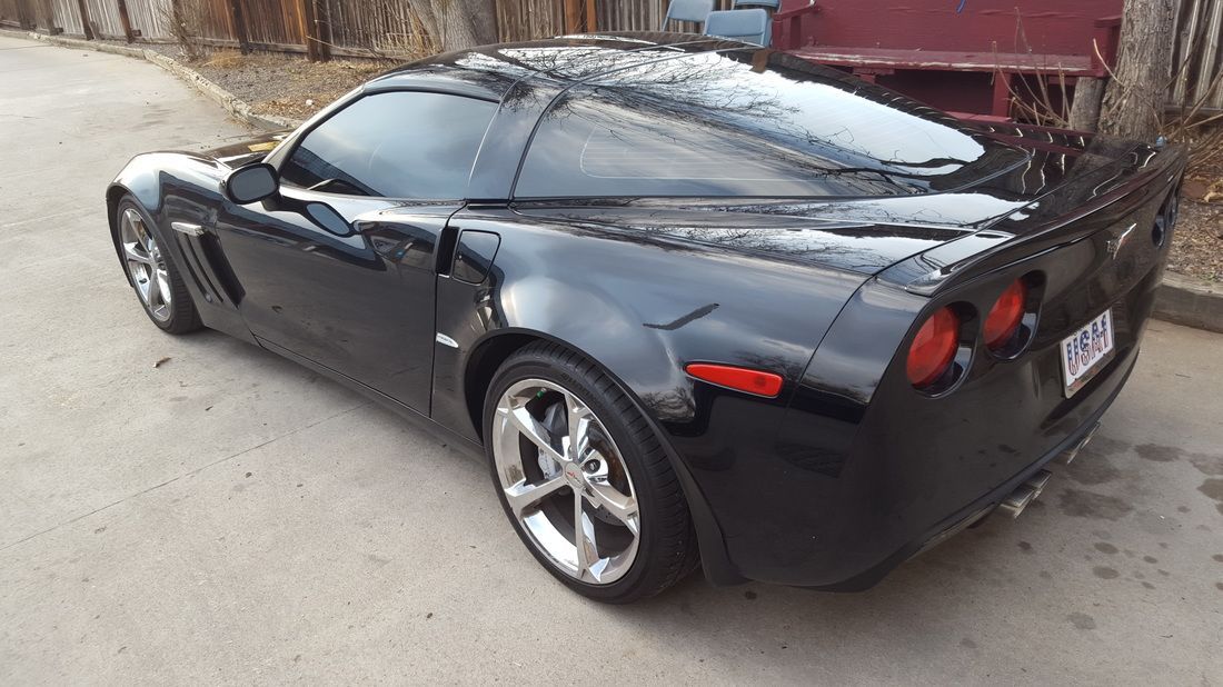 A black sports car is parked on the side of the road.