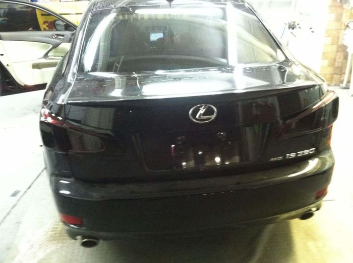 A black lexus car is parked in a garage