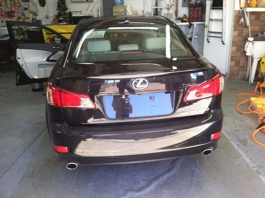 A black lexus car is parked in a garage