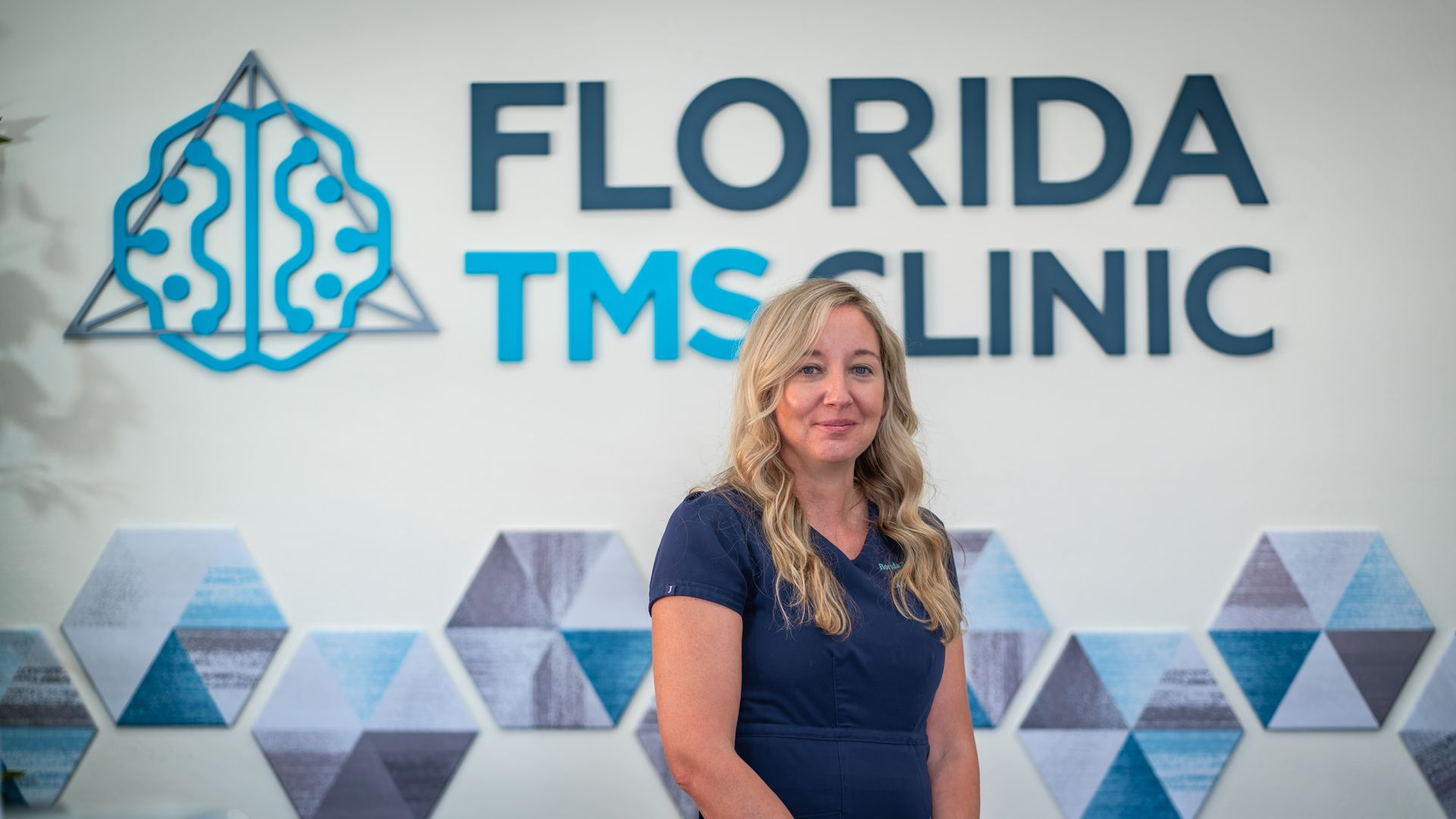 Woman in a blue shirt stands in front of a