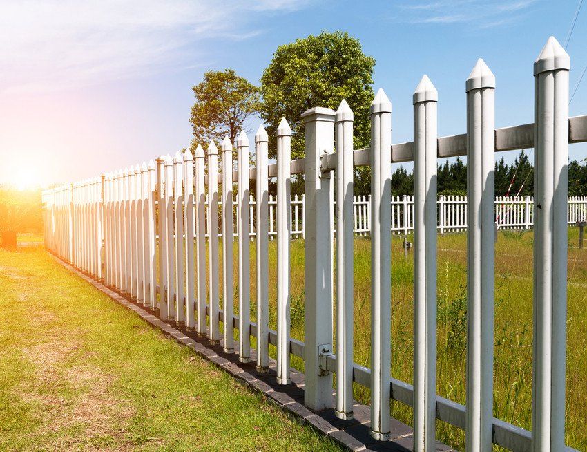 White fencing with trees behind