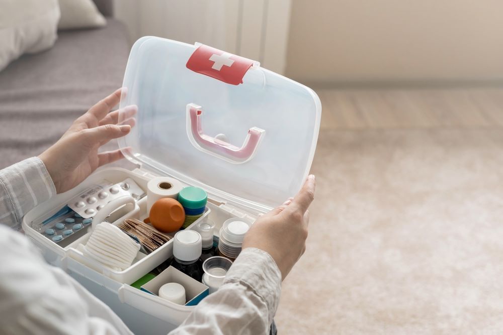 A Person Is Holding a First Aid Kit Filled with Pills and Bottles — Mackay Cleaning & Packaging Supplies in Mackay, QLD