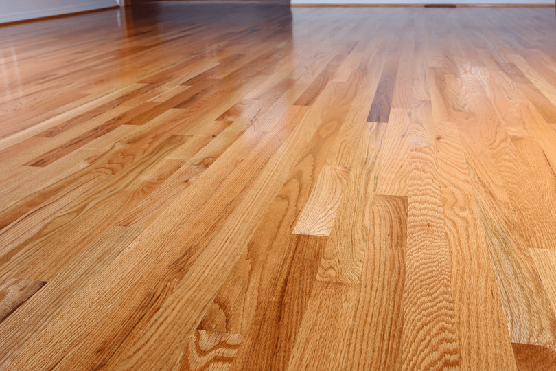 Shiny, polished light-colored hardwood flooring with visible wood grain and planks.