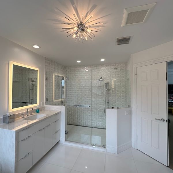 A bathroom with a sink a mirror and a walk in shower