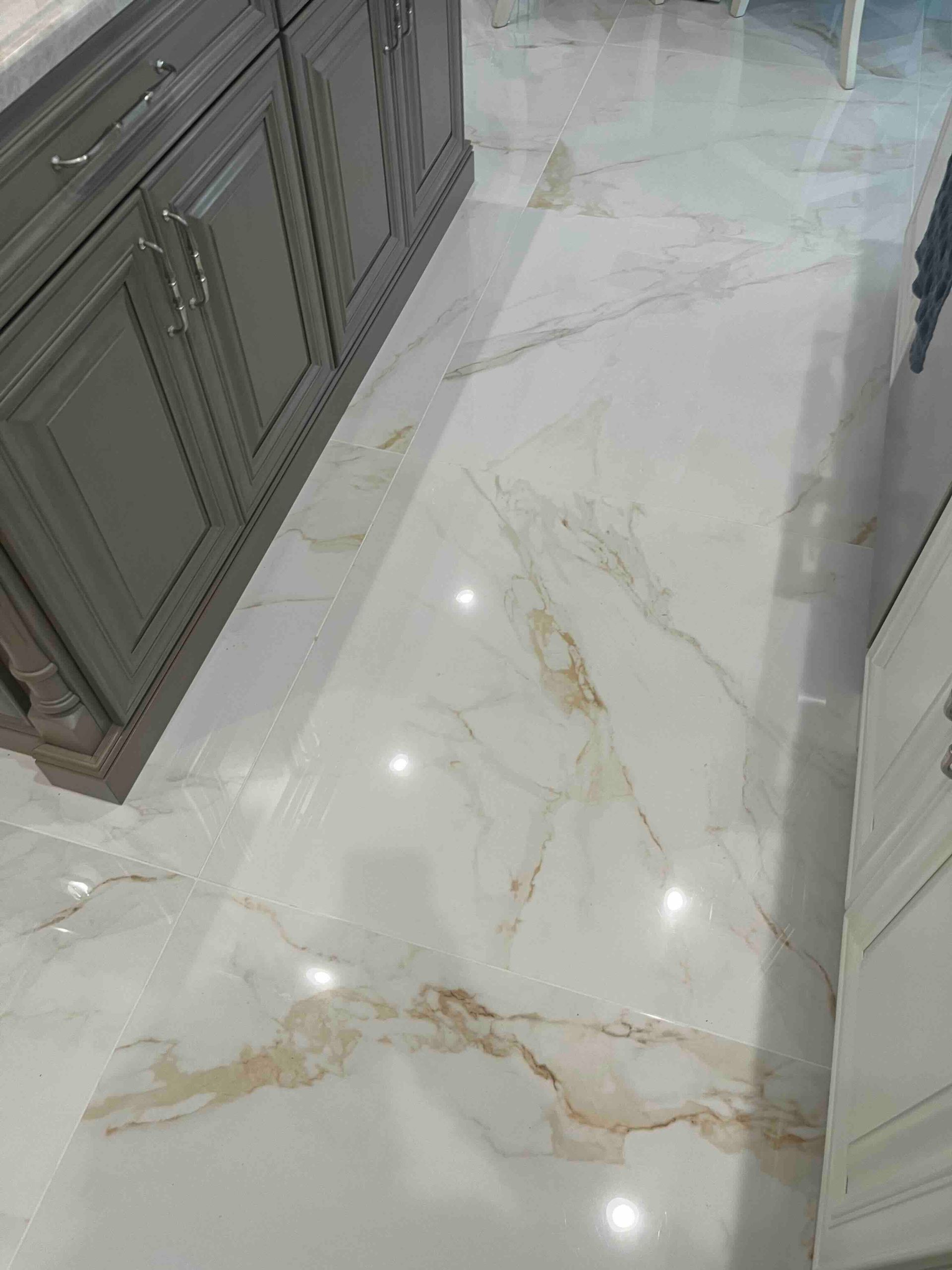 A kitchen with a marble floor and cabinets.
