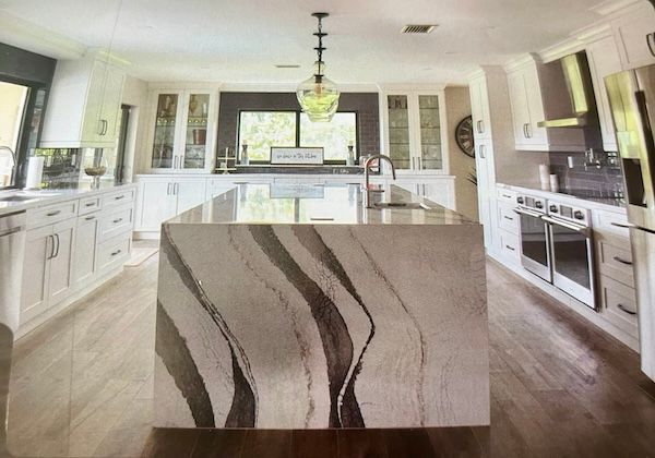 A kitchen with a large island in the middle of it.