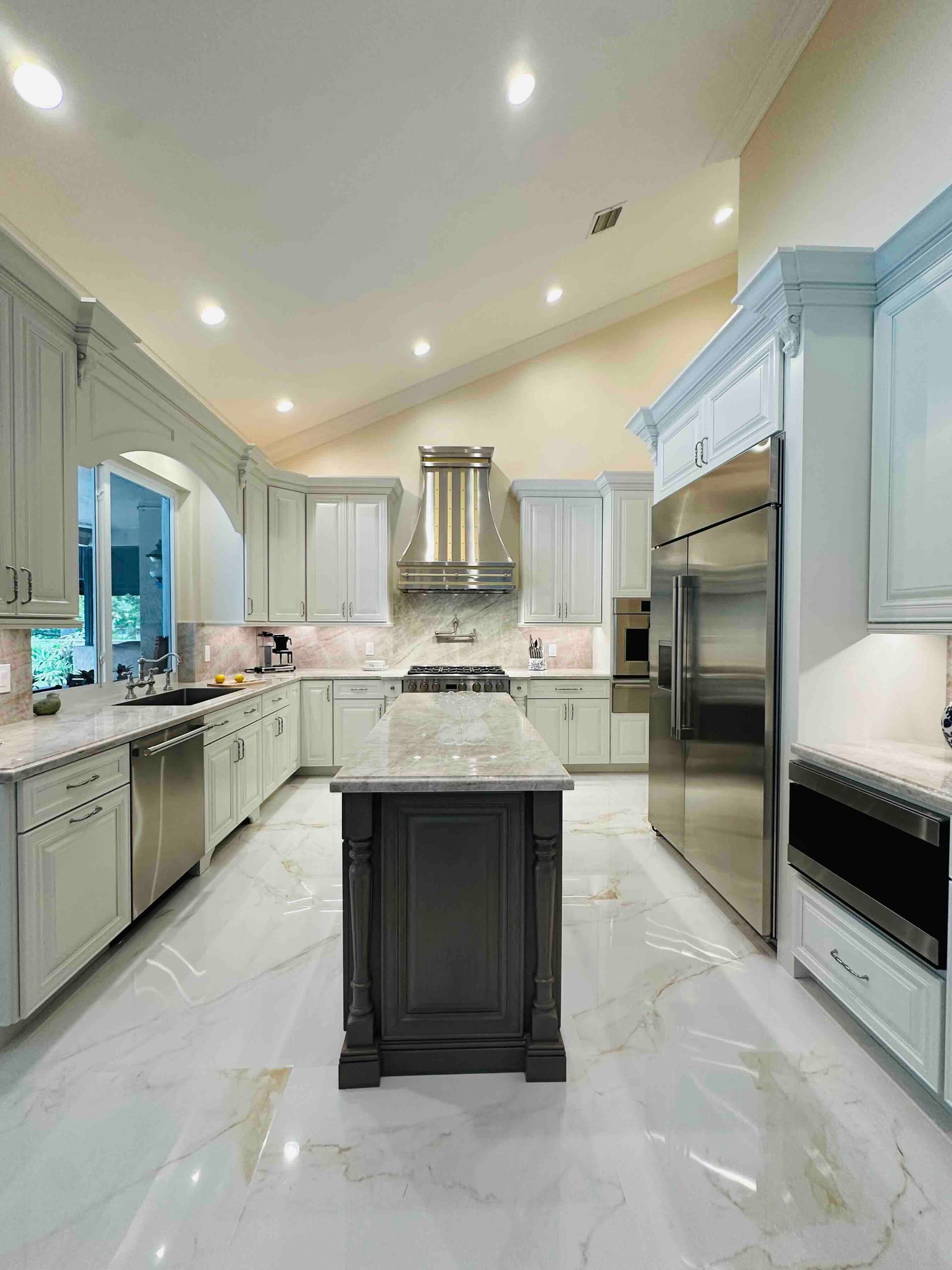 A large kitchen with white cabinets and stainless steel appliances