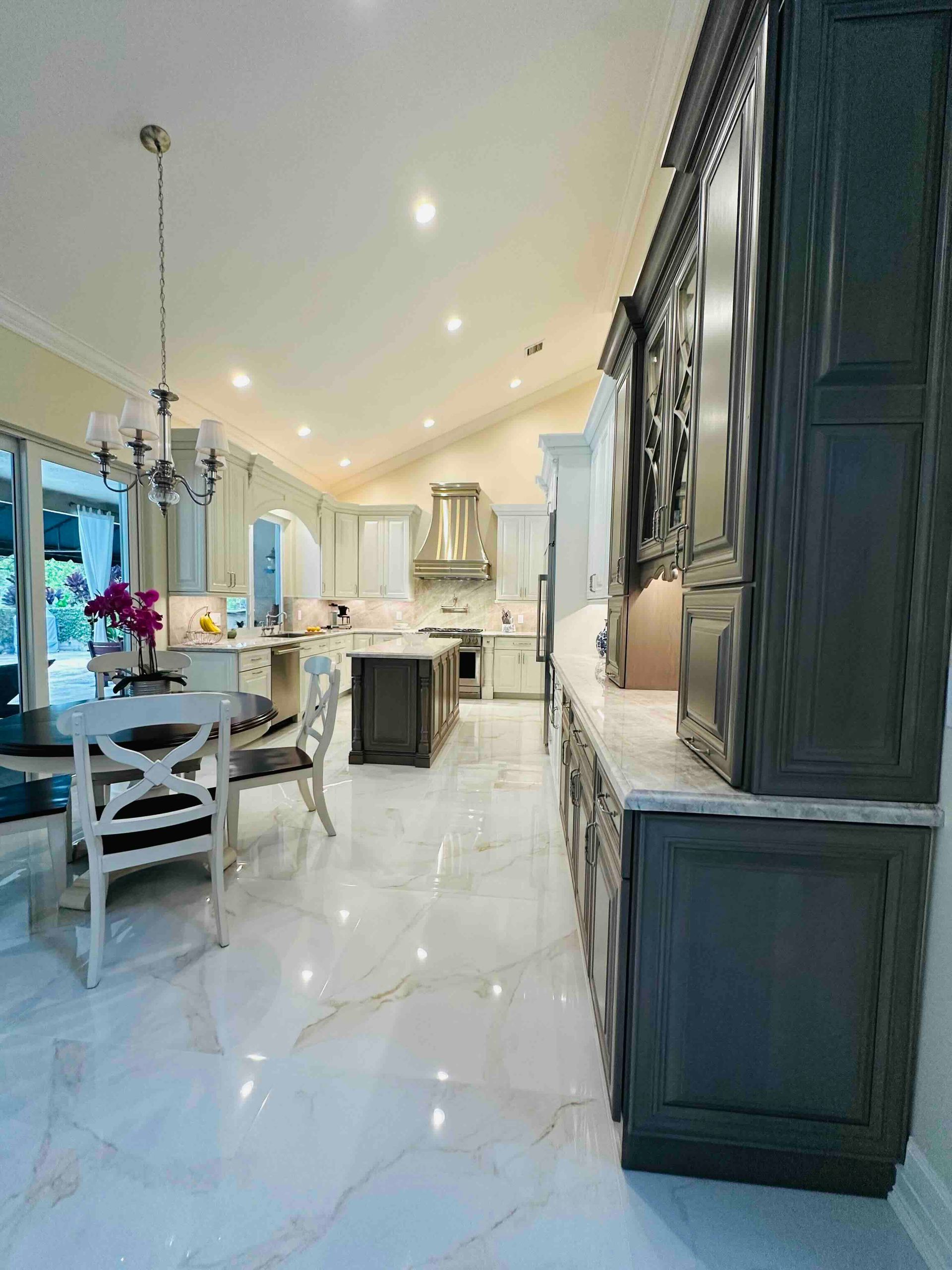 A kitchen and dining room in a house with a marble floor.