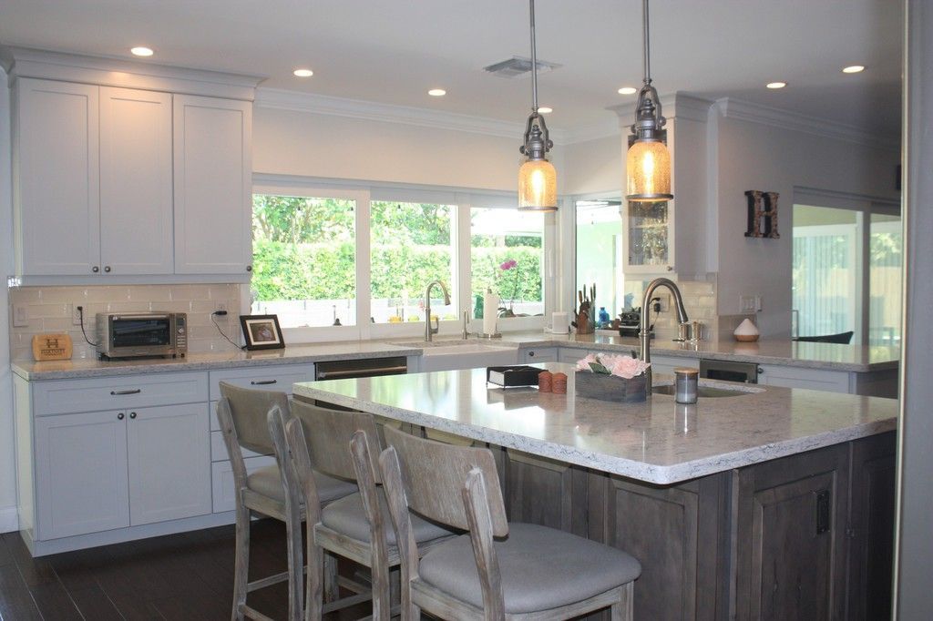 A kitchen with white cabinets and a large island.