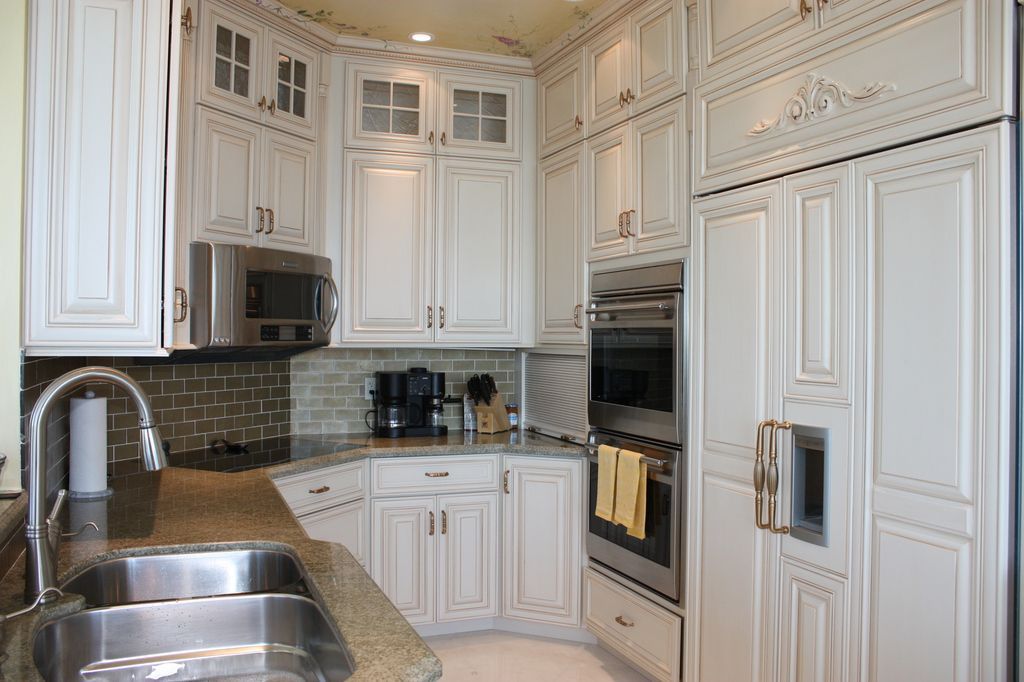 A kitchen with white cabinets and stainless steel appliances.