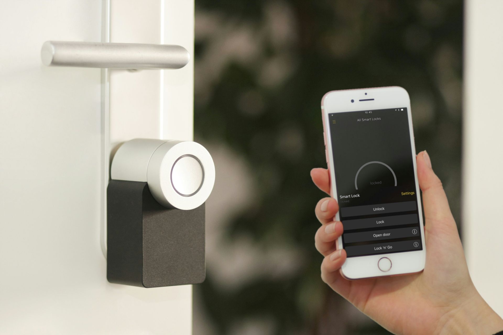 A person unlocks a door with a smartphone. The door has a smart lock.