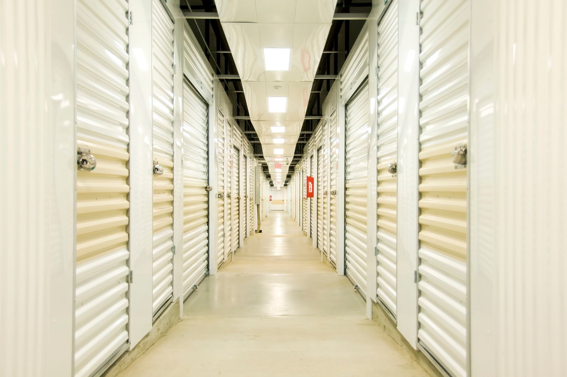 Climate-Controlled Self-Storage—Self-storage hall with lights, locks, doors, and concrete floor.