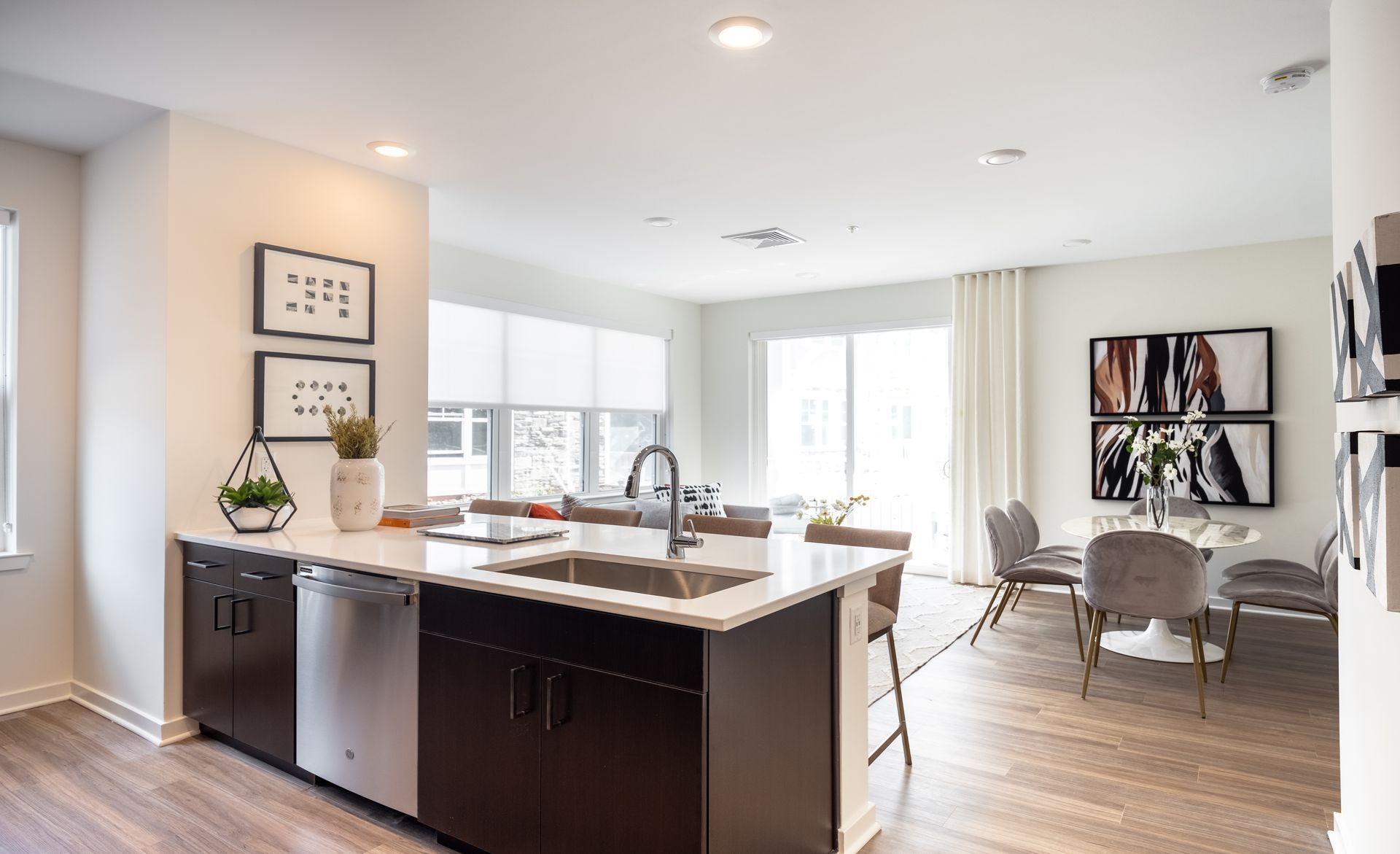 Modern kitchen and dining area with island, stainless steel appliances, and table with chairs.