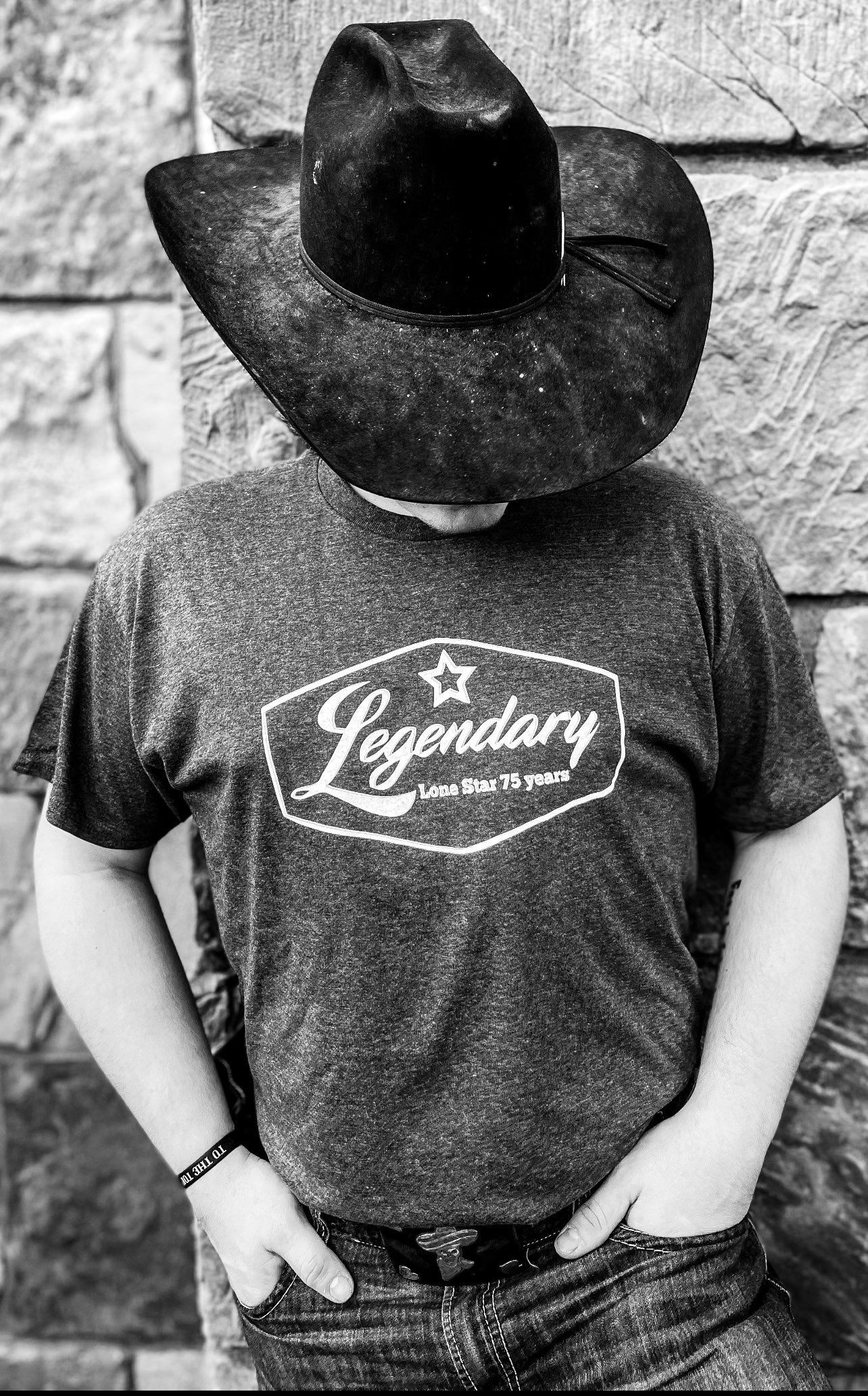 A man in gray Legendary tee is standing in front of a wall