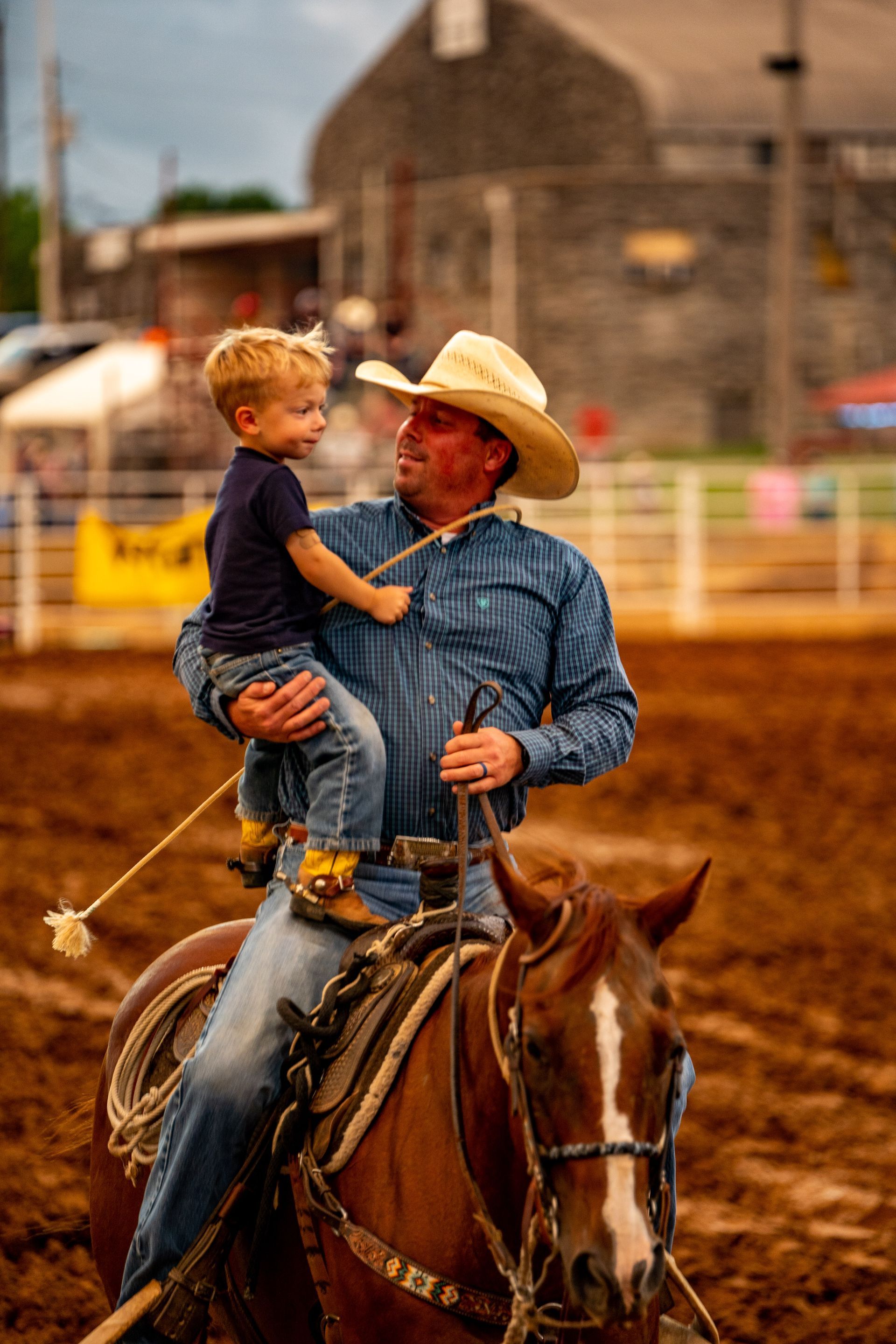 A man is riding a horse with a little boy on his back.