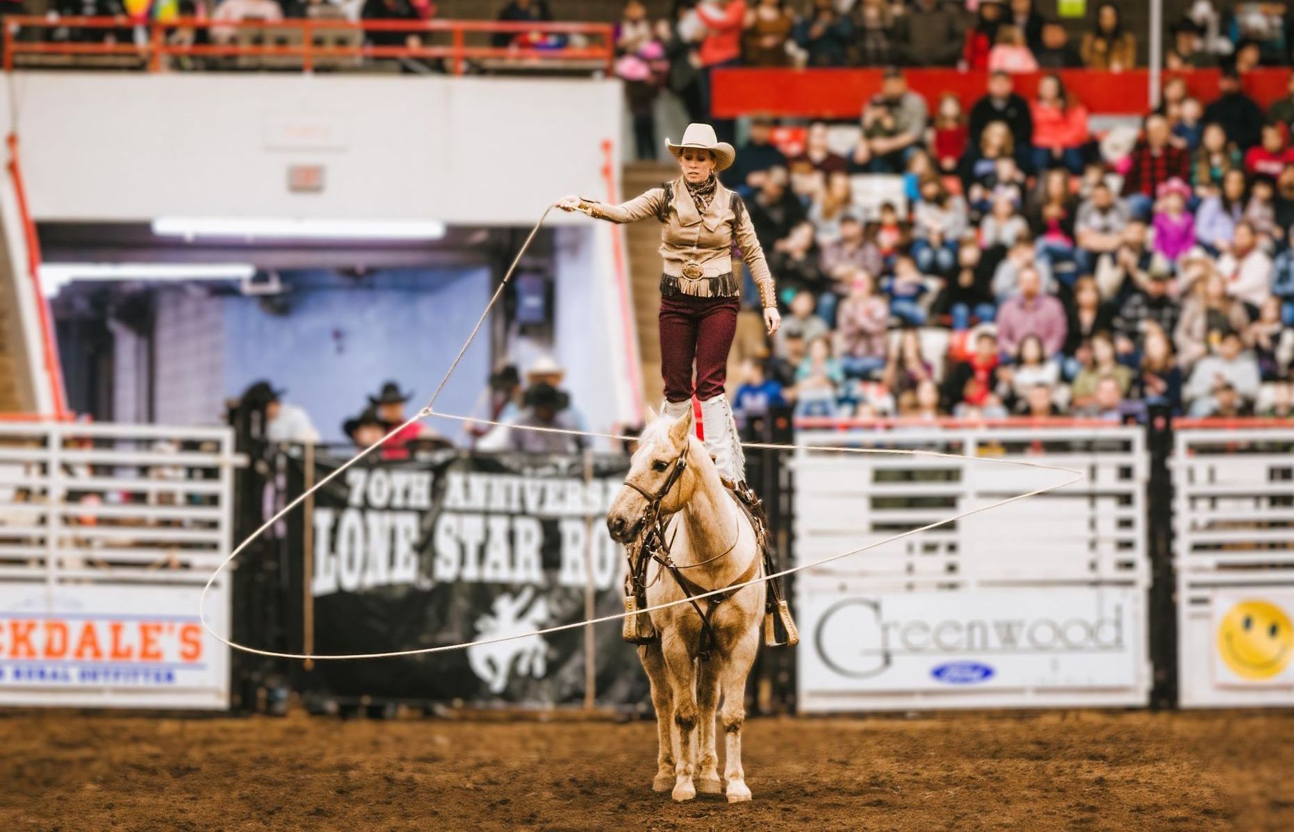 A man is riding a horse in a rodeo arena.