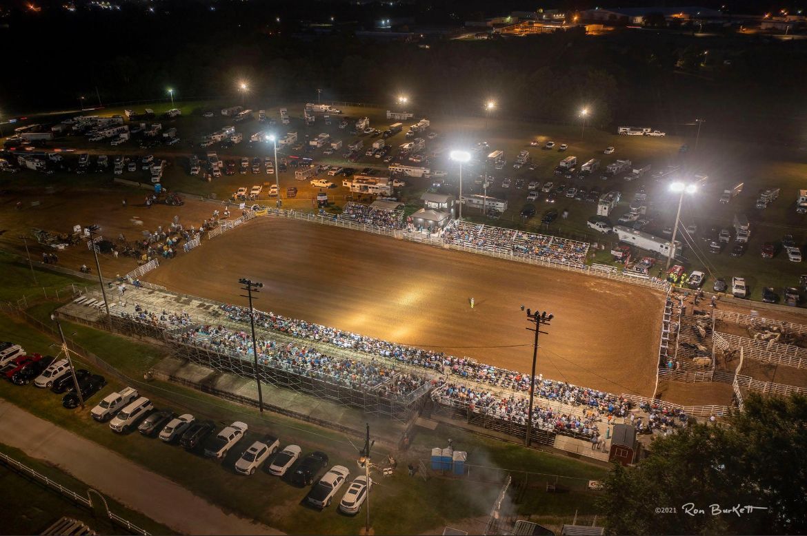 An aerial view of a rodeo arena at night.