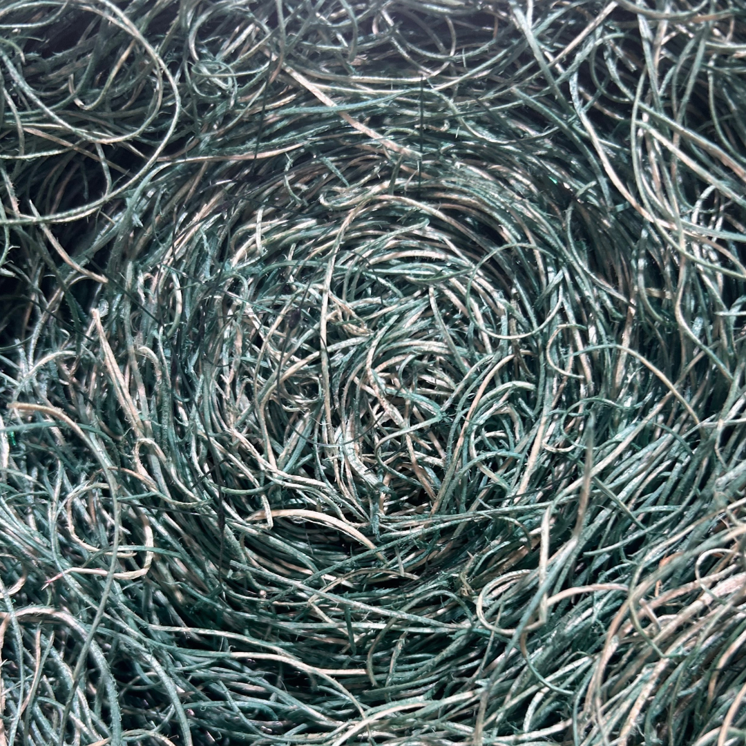 Tightly woven, teal-colored  Curlex metal wire forming a circular nest-like pattern.