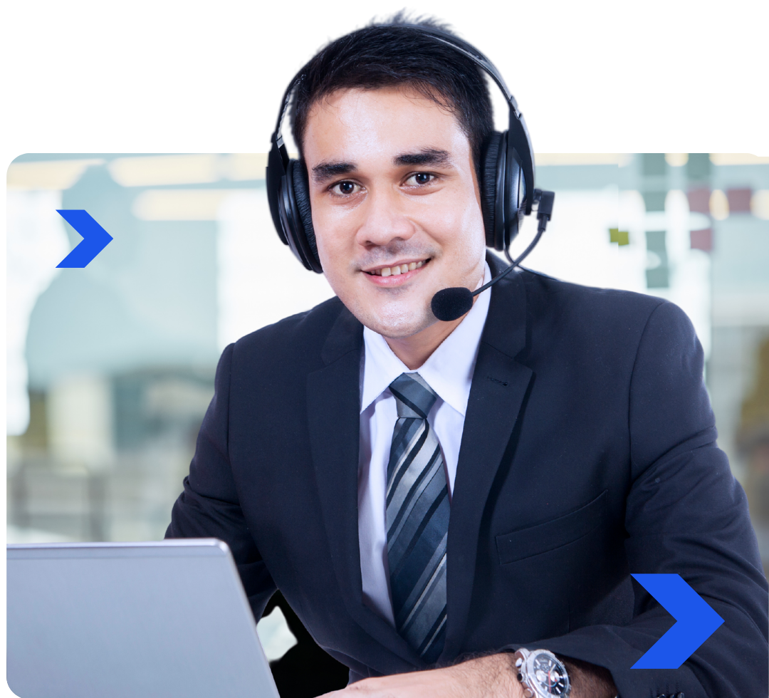 A man wearing headphones and a tie is sitting in front of a laptop computer.