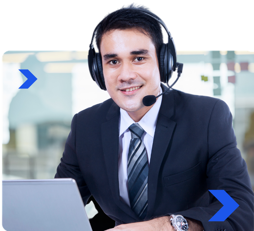 A man wearing headphones and a tie is sitting in front of a laptop computer.