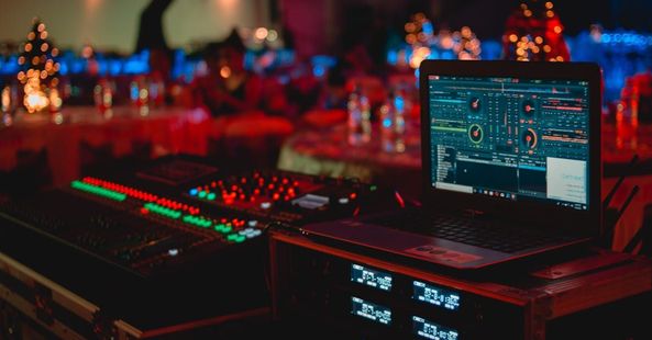 A laptop is sitting on a table next to a mixer