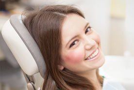 A smiling young lady in the dentist's chair