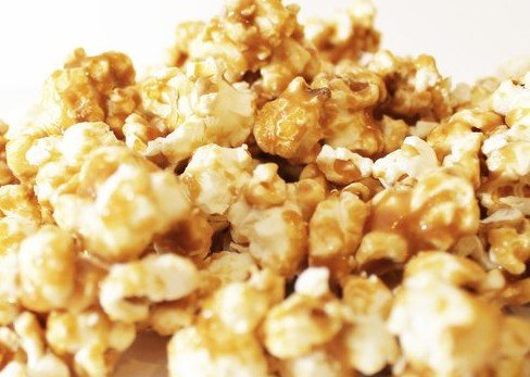 a pile of toffee caramel popcorn with white chocolate and peppermint candies