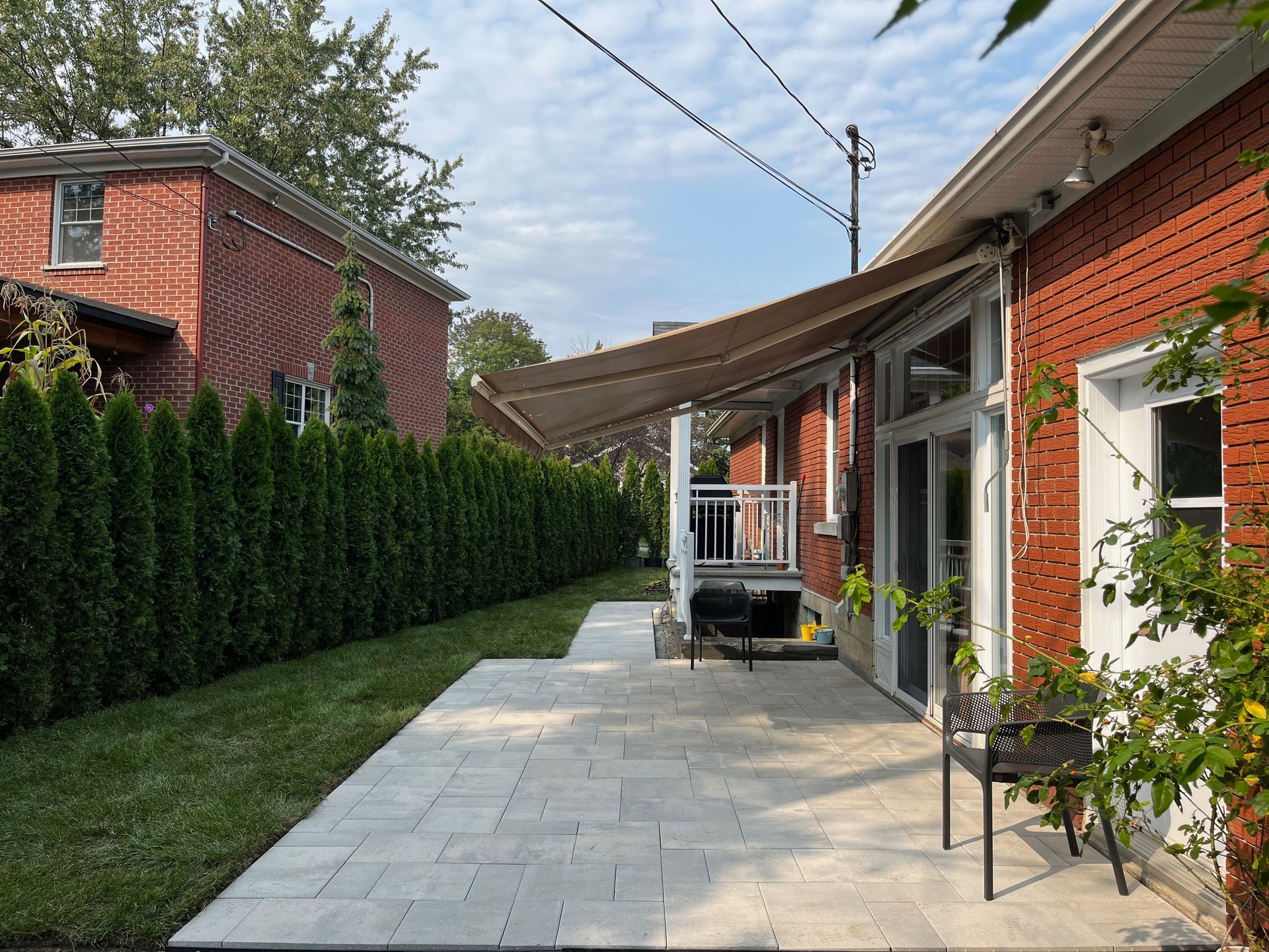 Une maison en briques avec un patio et un auvent dans l'arrière-cour