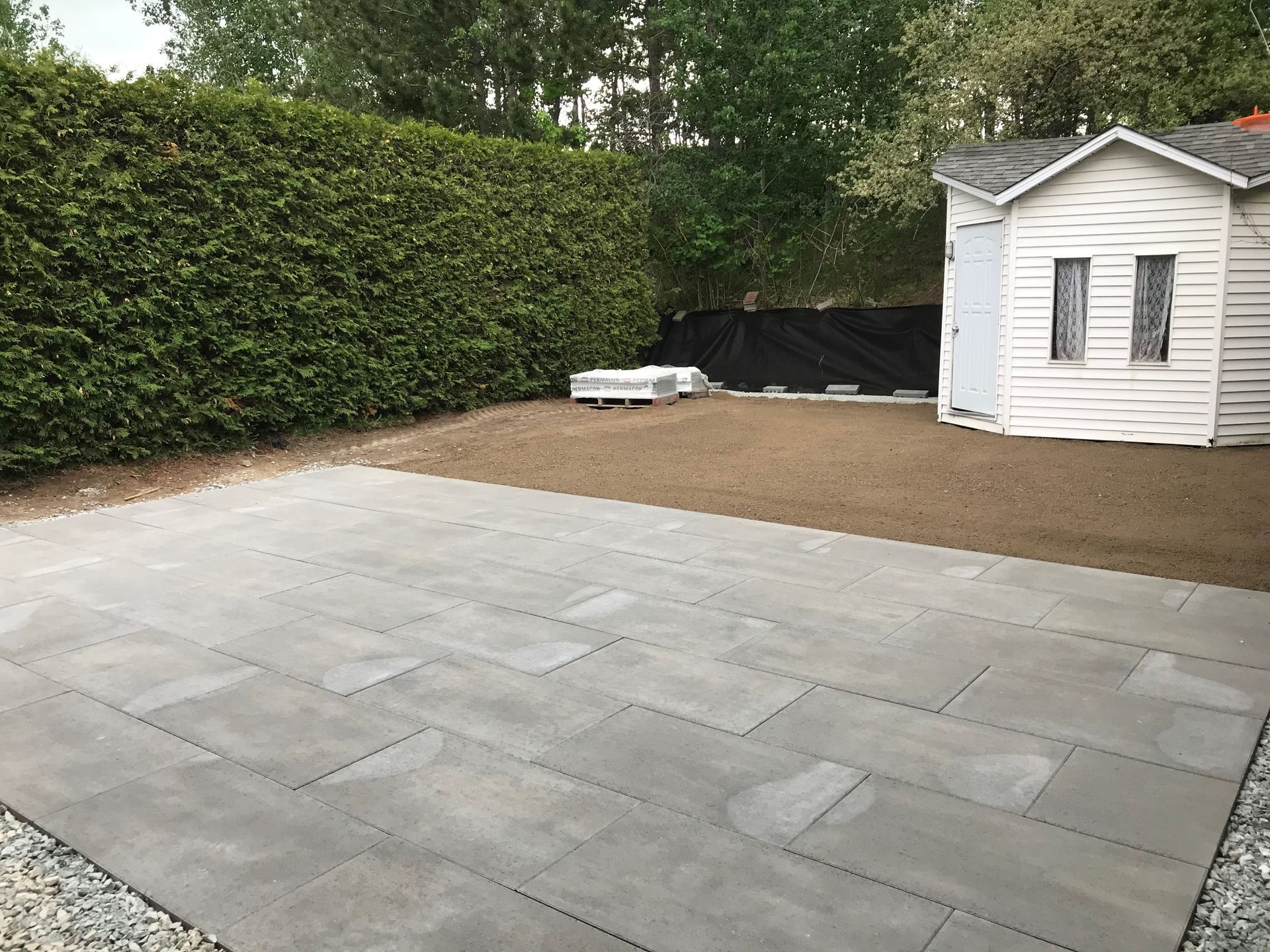 Un patio avec un hangar blanc en arrière-plan