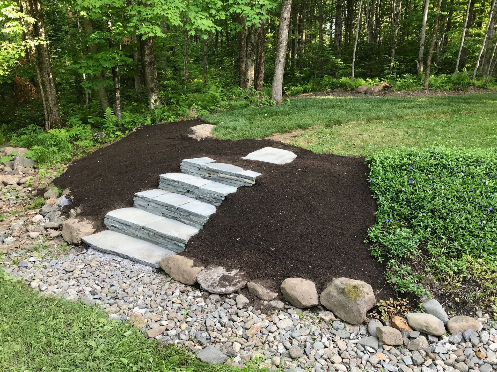 Un ensemble de marches menant à une colline rocheuse dans une cour.