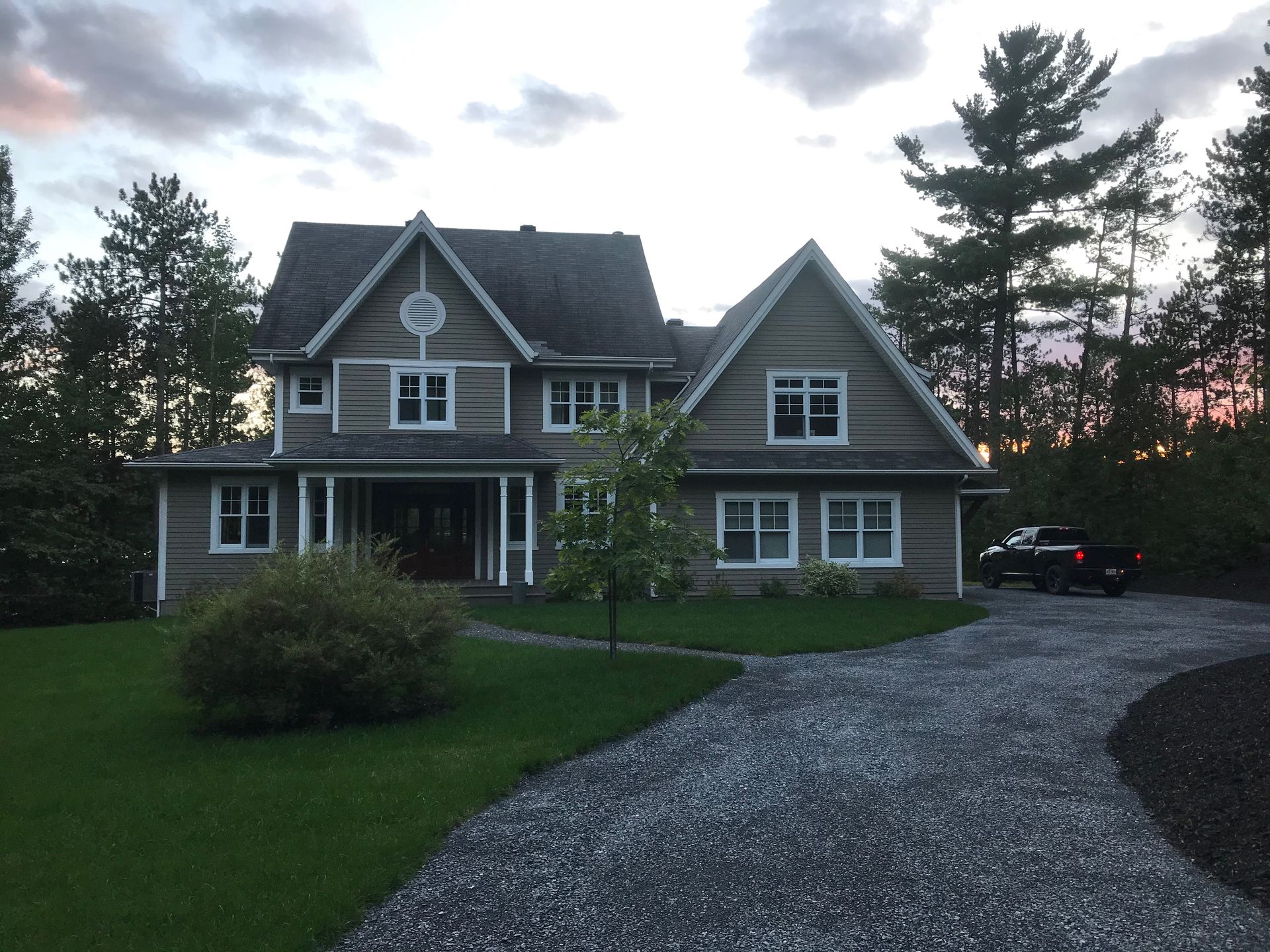 Une grande maison avec une allée de gravier devant elle