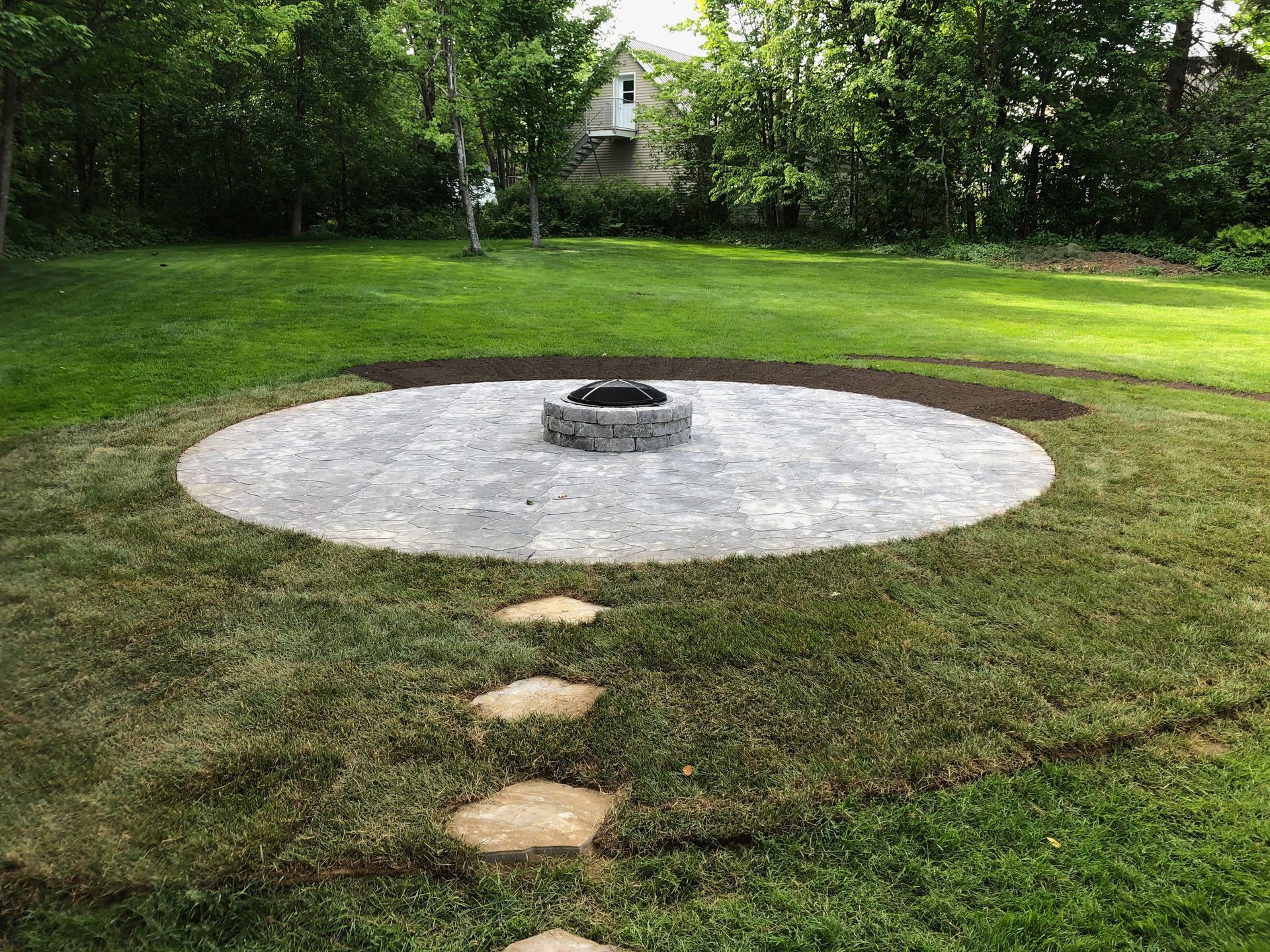 Un foyer est installé au milieu d'une pelouse verte luxuriante.
